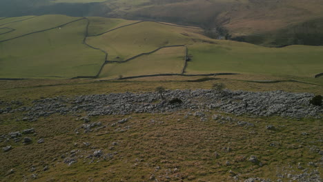 Ein-Felsiger-Hügel-Zieht-Sich-Zurück-Und-Enthüllt-Grüne-Patchwork-Felder-In-Der-Englischen-Landschaft-In-Ingleton,-Yorkshire,-Großbritannien