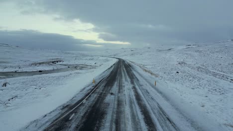 Snowy-Road-in-Iceland-Frozen-Tundra,-Aerial-Drone-Flight-with-Copy-Space
