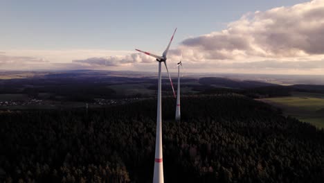 Zwei-Windkraftanlagen-Im-Wald-Bei-Wunderschönem-Sonnenuntergang