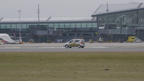 Safety-Car-Driving-Past-Lecha-Walesy-Airport-In-Gdansk