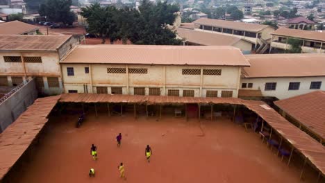 Luftaufnahme-Tief-über-Menschen,-Fußball-Auf-Den-Straßen-Des-Bewölkten-Yaoundé,-Kamerun