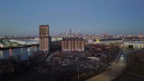 Drone-shot-rising-over-the-Damen-Silos-approaching-the-skyline-of-Chicago,-misty-morning-in-Pilsen,-Illinois,-USA