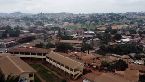 Aerial-view-tilting-over-suburban-buildings-in-Yaounde-city,-Cameroon,-Africa