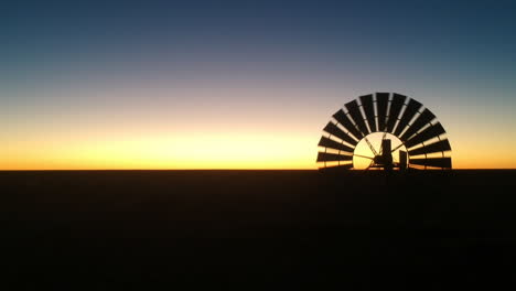 Cinematic-drone-video-from-silhouette-windmill-black-and-red-orange-sunset-australia