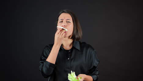 Young-Female-Vegan-Eating-Cabbage-Leaf-Passionately-in-Front-of-Camera,-Slow-Motion