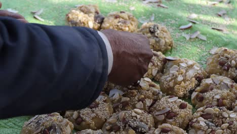 Hand-Placing-Nuts-Onto-Row-Of-Jaggery-Lumps