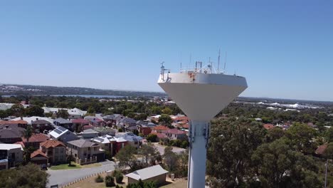 Aerial-Rise-Up-Shot-Of-A-White-Metal-Water-Tower-In-Joondalup,-Perth-Australia