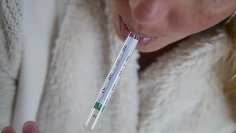 Close-up-of-a-sick-woman-taking-her-oral-temperature