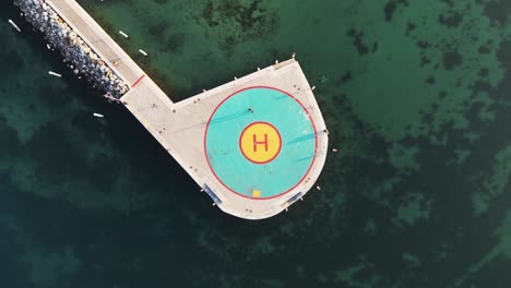 Aerial-view-helicopter-landing-site-located-in-lake-near-harbor-with-boat