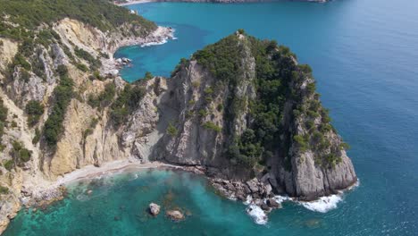 Aerial,-tilt-down-view-over-rocky-cliff-beach-with-no-people,-Corfu,-Greece,-slow-motion
