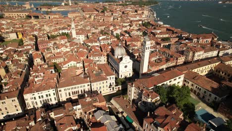 City-Architecture-and-Sea-Shore-of-Venice,-Italy,-Aerial-Drone-Fly-Above-Basilica,-Venetian-Lagoon-and-Buildings-during-Clear-Sunny-Daytime,-Summer-in-Europe