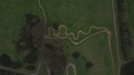 Spinnig-aerial-view-of-downhill-mountain-biking-trail-in-Hadleigh-Park,-drone-4K