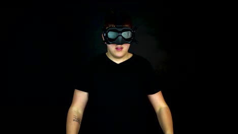 Young-Man-Wearing-VR-First-Person-View-Headset,-Studio-Shot-on-Black-Background