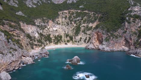 Aerial,-approaching-pebble-cliff-beach-with-no-people-on-Corfu,-Greece,-slow-motion