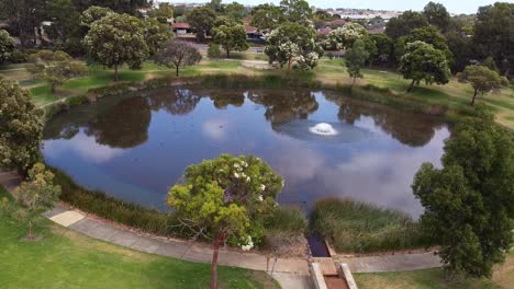 Aerial-Reveal-Of-Circular-Lake-With-Rainwater-Spillway---Perth,-Australia