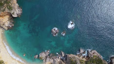 Aerial,-top-down,-rotating-view-of-rocky-cliff-beach-with-no-people,-Corfu,-Greece,-slow-motion