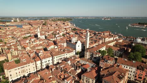 Aerial-Drone-View-Above-City-of-Venice,-Italy-in-Summer,-Blue-Sky-and-Sea-Water,-Traditional-Houses-with-Red-Tile-Roofs,-Canal-Street-and-Neighborhood-Architecture