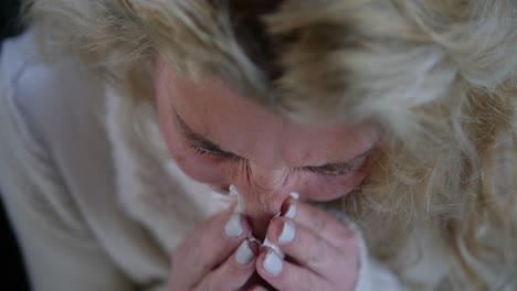 Extreme-close-up-of-a-sick-woman-sneezing-into-a-tissue