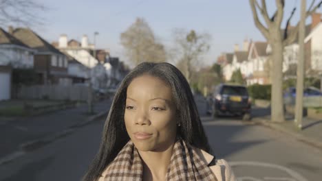 Confident-black-businesswoman-walking-on-street-road-with-sunlight-on-face-in-central-London