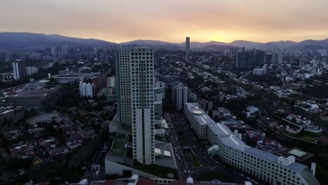 Aerial-view-around-the-Arcos-Bosques-office-and-shopping-complex,-dramatic-sunset-in-Mexico-city