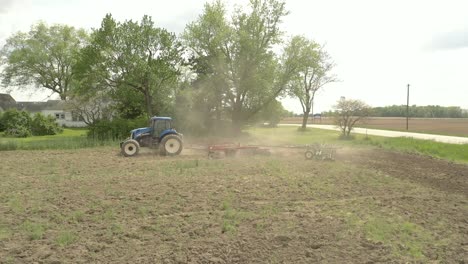 Farmer-in-tractor-cultivating-crop-in-field-take-1