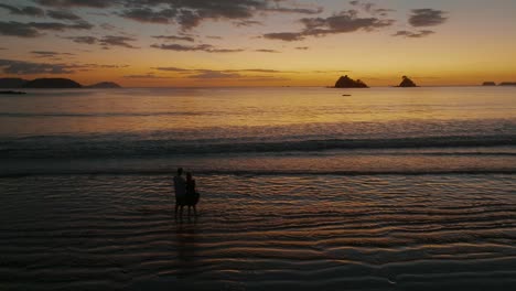 Romantische-Paarsilhouette-Bei-Sonnenuntergang-Am-Strand-In-Costa-Rica---Drohnenaufnahme