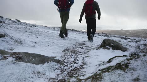 Two-men-hiking-through-frozen,-open-tundra