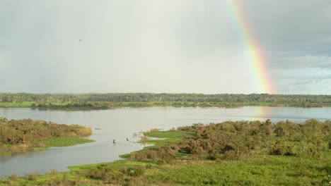 Amazonas-In-Der-Nähe-Von-Iquitos,-Peru-Mit-Regenbogen-Und-Vorbeifahrendem-Boot---Zeitraffer-4k,-24fps