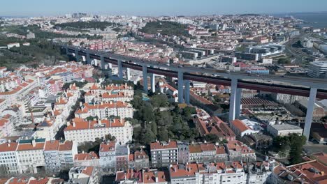 Aerial-view-of-traffic-on-25-of-April-bridge-over-the-Lisbon-city-near-Tagus-River-at-sunrise-in-Portugal