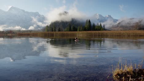 Blond-man-is-doing-an-ice-bath-in-a-beautiful-mountain-lake-in-austria