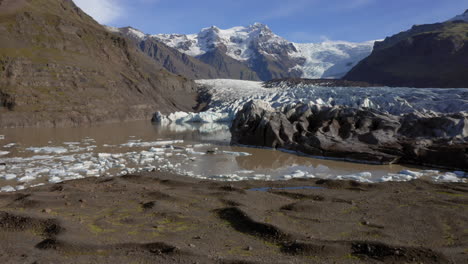 Luftaufnahme:-Rückwärtsaufnahme-Einer-Person,-Die-An-Einem-Sonnigen-Tag-Auf-Einem-Hügel-In-Der-Nähe-Des-Svinafellsjökull-Gletschers-Steht