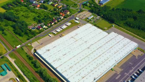 Aerial-view-of-a-semi-trucks-with-cargo-trailers-standing-on-warehouses-ramps-for-loading-unloading-goods-on-the-big-logistics-park-with-loading-hub