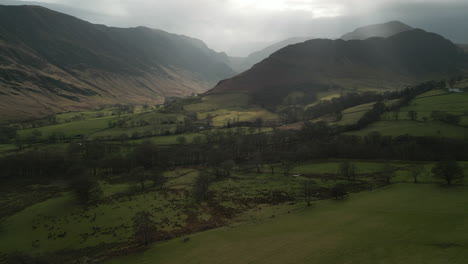 Flying-towards-misty-mountains-over-green-valley-in-winter-at-English-Lake-District-UK