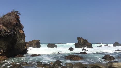 Wunderschöne-Strandlandschaft-Mit-Harten-Meereswellen,-Die-Den-Felsen-In-Indonesien-Treffen