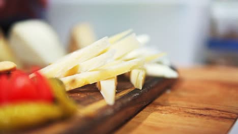 Macro-Shot-Of-Person-Preparing-Cheese-Platter-To-Be-Served-In-Restaurant