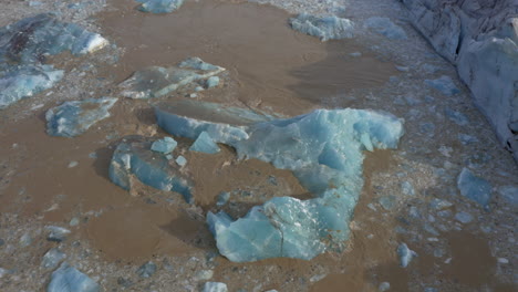 Aerial:-Top-down-view-of-collapsing-icebergs-due-to-glacier-calving-on-Svinafellsjokull-glacier-in-Iceland