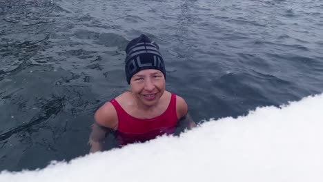 Close-up-of-a-woman-taking-an-ice-bath-in-a-lake-during-snowfall