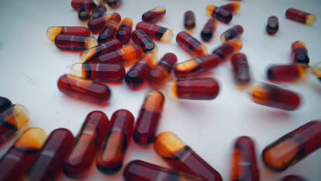 Red-krill-oil-capsules-bouncing-over-a-white-surface,-slowly-filling-the-frame