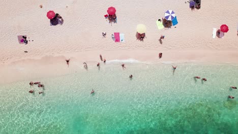 Aerial-top-down-of-people-relax-on-white-sand-beach-with-transparent-mediterranean-sea-in-Sardinia,-Background