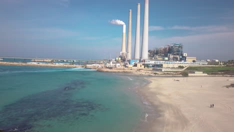 Aerial-shot-of-the-Hadera-Desalination-Plant,-Israel,-over-the-beach-and-water
