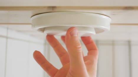 Man-adjusting-a-disc-type-air-valve-on-a-bathroom-ceiling