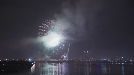 Colorful-fireworks-light-up-sky-for-Lunar-New-Year-and-Tet-holiday-over-reflecting-in-the-Han-River-of-Danang,-Vietnam