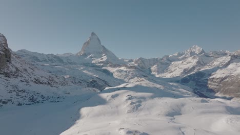Fröhliche-Junge-Frau-Auf-Schneebedecktem-Felsen,-Die-Euphorisch-Die-Arme-Im-Atemberaubenden-Bergpanorama-Der-Schweizer-Alpen-Hebt