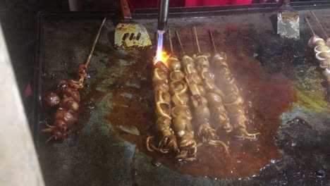 process-of-making-and-barbequing-of-Squid-Skewer,-it's-seasoned-with-tomato-sauce-and-chili-paste
