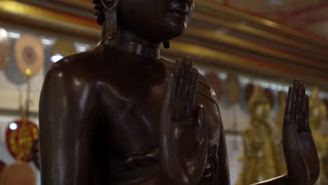 Buddha-wood-statue-stand-up-at-buddhist-temple-rehabilitation-Bangkok-Thailand