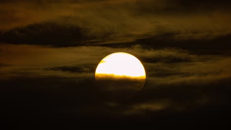 African-safari-sunset-telephoto-close-up-of-savannah-african-sun-setting-below-dramatic-clouds,-static-timelapse