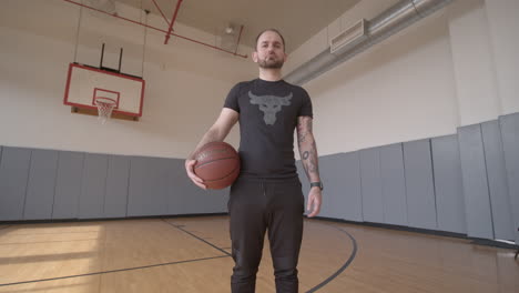 Low-Angle-Wide-of-a-Man-Standing-on-a-Basketball-Court