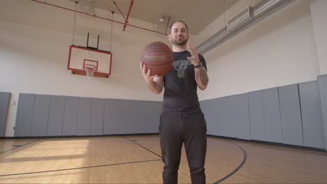Low-Angle-Wide-of-a-Man-Playfully-Holding-a-Basketball