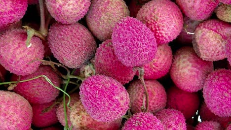 Artistic-shot-of-tropical-fruit-lychee-known-as-litchi-chinensis-berries,-top-fixed-view-with-rotation