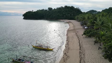 Luftaufnahme-Von-Bangka-Booten-Und-Spielenden-Kindern-An-Einem-Idyllischen-Weißen-Sandstrand-In-Catanduanes,-Philippinen